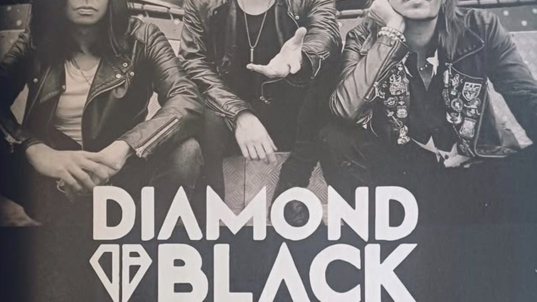 Diamond Black press photo from Sonic Seducer magazine feature with band members seated in front of fairground ride